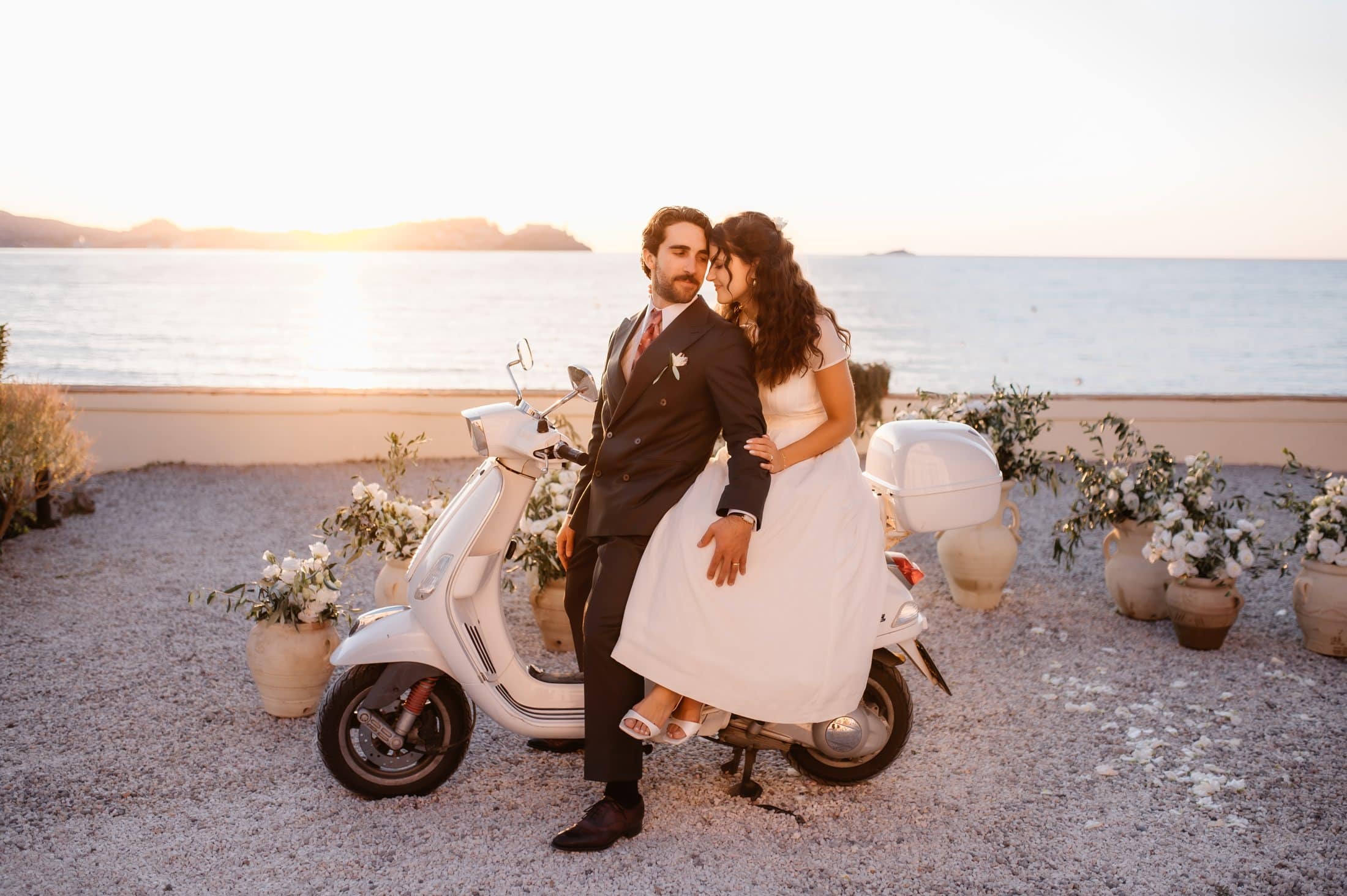 Home 10 Una coppia di sposi su una Vespa davanti al mare al tramonto